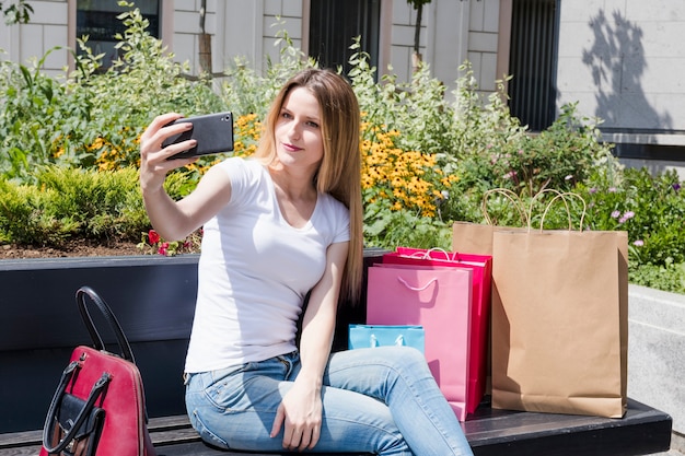 Shopaholic Frau, die selfie auf Smartphone nimmt