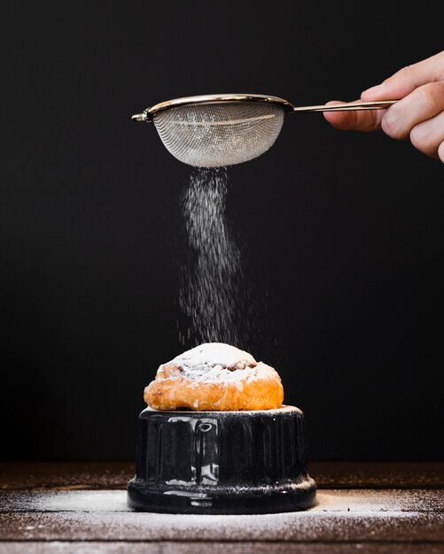 Sieben Sie das Zutropfen von Zucker auf Pain aux Rosin