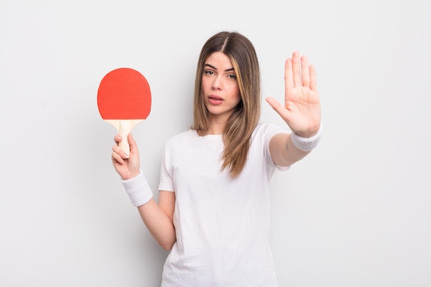 Sieht ernst aus und zeigt eine offene Handfläche, die eine Stopp-Geste macht