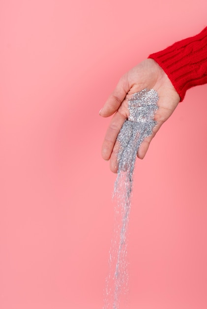 Kostenloses Foto silbernes funkeln in der hand gehalten auf rosa hintergrund