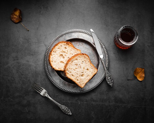 Silbernes Tischbesteck der Draufsicht gegründet mit Brot und Tee