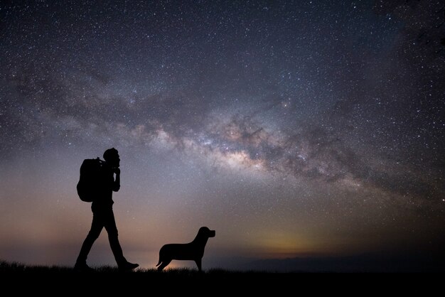 Silhouette der jungen Backpacker Mann zu Fuß während des Sonnenuntergangs.