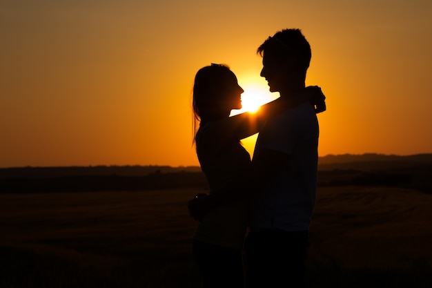 Silhouette der jungen Paar im Feld.
