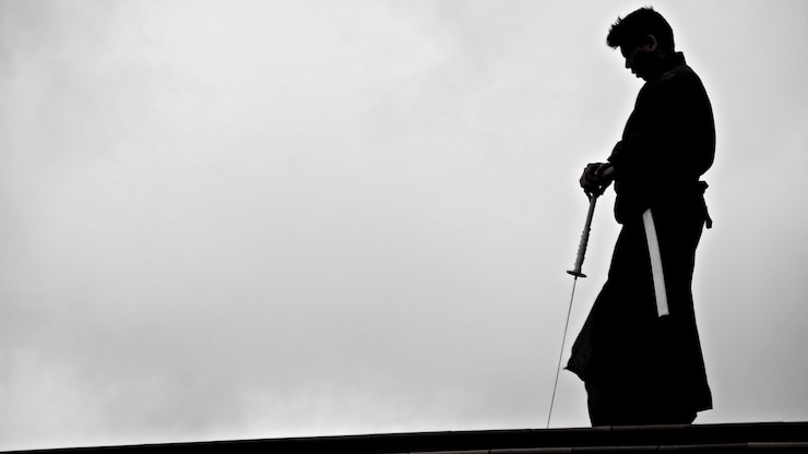 Kostenlose Foto silhouette eines japanischen mannes im kimono, der mit einem traditionellen japanischen katana-schwert übt