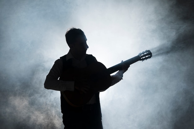 Silhouette eines Musikers auf der Bühne, der Gitarre spielt