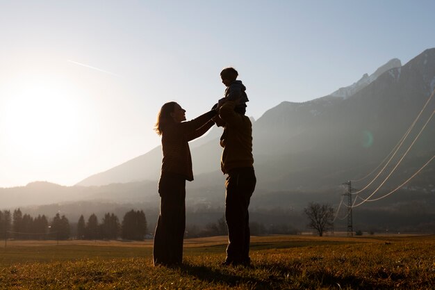 Silhouetten von Familien in der Natur bei Sonnenuntergang