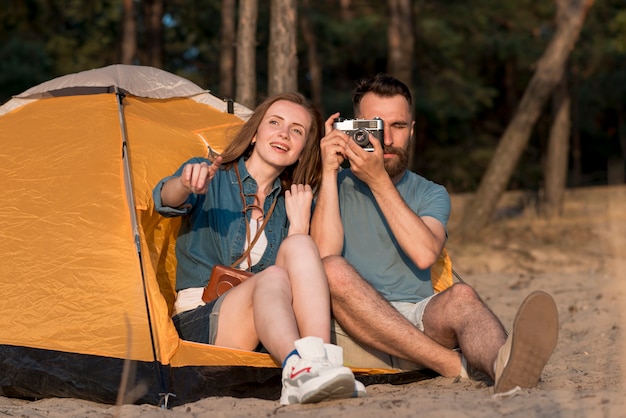 Sitzende Paare, die ein Foto durch ein Zelt machen