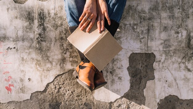 Sitzende Personenhände, die offenes Buch halten