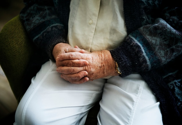 Kostenloses Foto sitzender älterer mann nah oben auf seinen händchenhalten