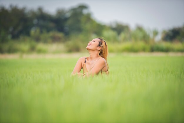 Sitzendes Gefühl der jungen Frau gut in der Rasenfläche.