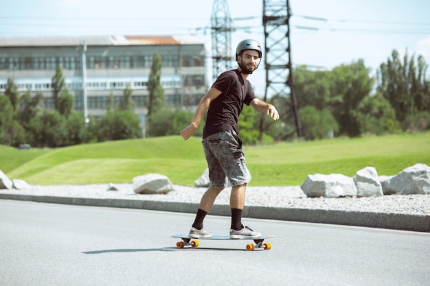 Skateboarder macht an einem sonnigen Tag einen Trick auf der Straße der Stadt.