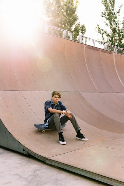 Kostenloses Foto skater junge sitzt in halber pfeife