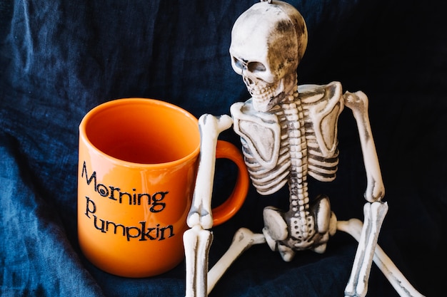 Kostenloses Foto skelett mit halloween-tasse