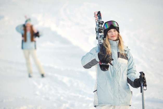 Kostenloses Foto skifahrer auf einem berghang, der vor dem hintergrund der schneebedeckten berge aufwirft