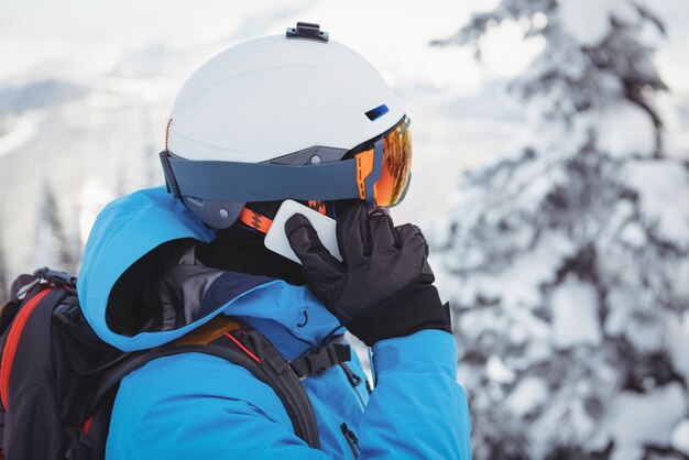 Skifahrer spricht auf dem Handy