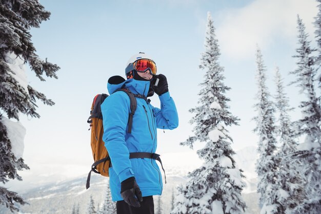 Skifahrer spricht auf dem Handy
