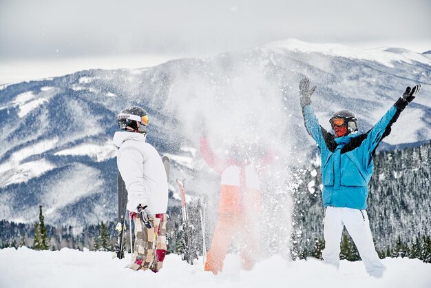Skifahrerteam, das Spaß in den schneebedeckten Bergen hat