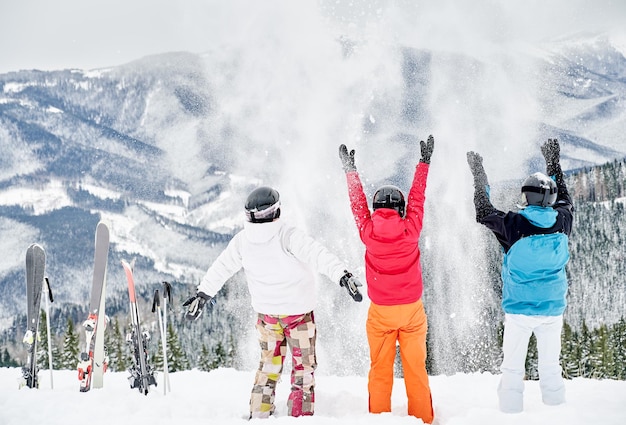 Skifahrerteam, das Spaß in den schneebedeckten Bergen hat