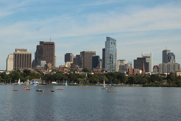 Skyline-Bild von Booten, die im Wasser nahe einer großen Stadt an einem sonnigen Tag segeln