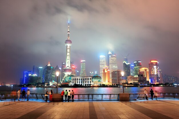 Skyline der Stadt Shanghai über Gehweg bei Nacht