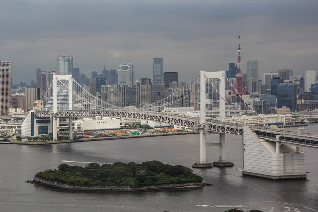 Skyline von Minato City Hochhäusern in der Nähe einer Regenbogen-Hängebrücke in Tokio, Japan