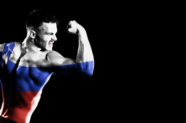 Kostenloses Foto slowenien-flagge auf schwarzem hintergrund des hübschen jungen muskulösen mannes
