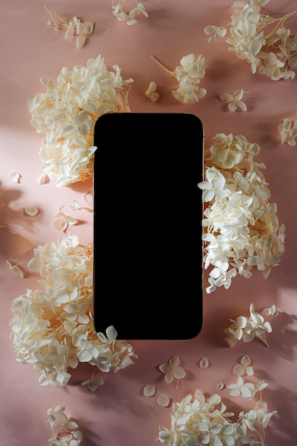 Smartphone-mockup mit weißen blumen auf rosa hintergrund gerätebildschirm-attrappe auf stilvollem hintergrund für präsentation oder appl-design Premium Fotos