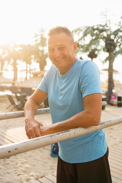 Kostenloses Foto smiley älterer mann, der während des trainings im park aufwirft