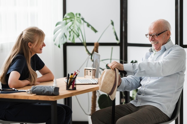 Smiley älterer Mann in einem Pflegeheim mit Krankenschwester