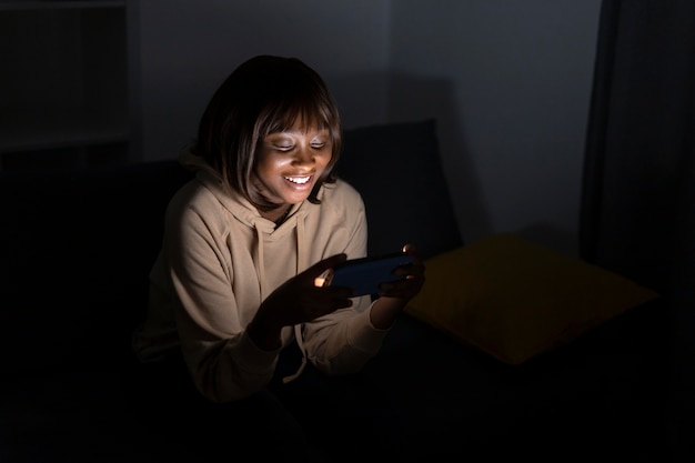 Smiley-Afroamerikanerin, die zu Hause einen Streaming-Dienst ansieht