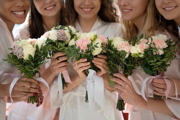 Kostenloses Foto smiley-brautjungfern, die blumensträuße halten