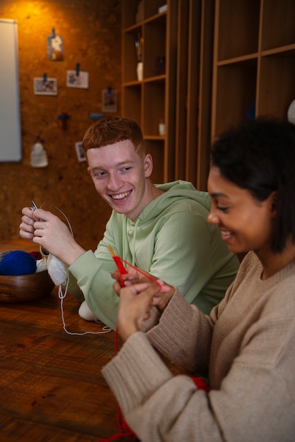 Smiley-Erwachsene mit mittlerer Aufnahme, die zusammen stricken