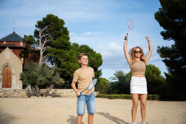 Kostenloses Foto smiley-familie der vorderansicht, die badminton spielt