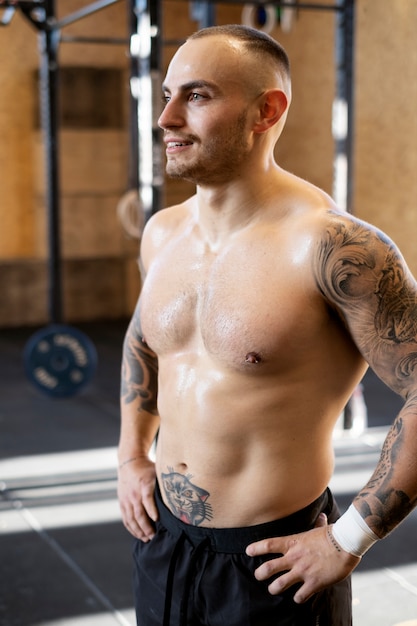 Smiley fitter Mann im Fitnessstudio voller Schuss