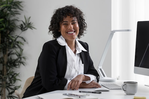 Smiley-Frau der Seitenansicht, die am Schreibtisch arbeitet