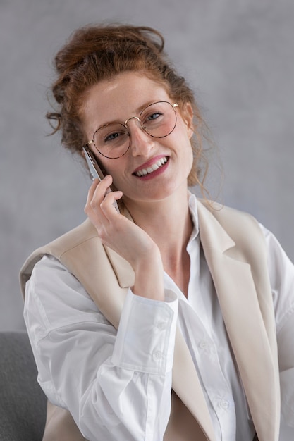 Smiley-Frau der Vorderansicht, die am Telefon spricht