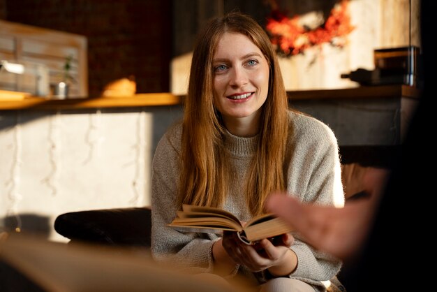 Smiley-Frau der Vorderansicht, die Buch hält