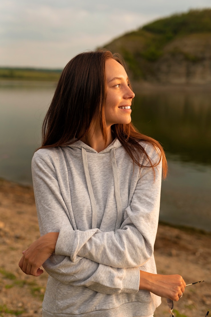 Kostenlose Foto smiley-frau der vorderansicht, die draußen aufwirft