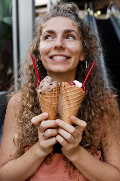 Kostenloses Foto smiley-frau der vorderansicht, die eis hält