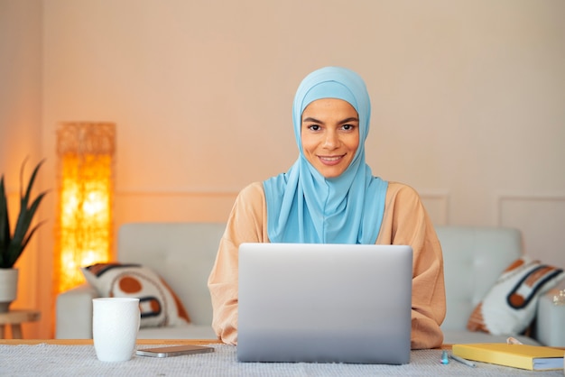 Kostenloses Foto smiley-frau der vorderansicht, die hijab trägt