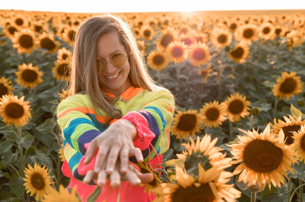 Smiley-Frau der Vorderansicht, die in der Natur aufwirft