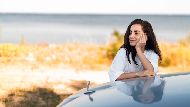 Kostenloses Foto smiley-frau, die am meer aufwirft