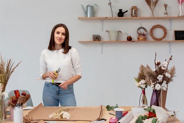 Smiley-Frau, die an einem Blumenladen arbeitet