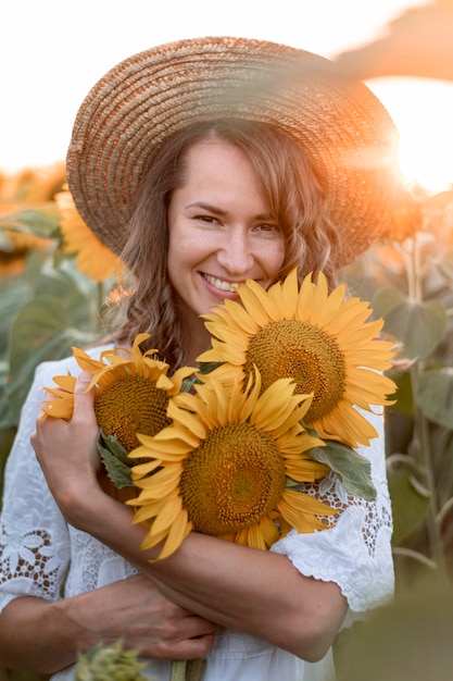 Smiley-Frau, die bei Sonnenuntergang aufwirft