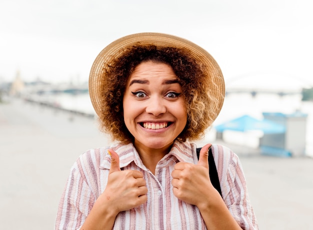 Kostenloses Foto smiley-frau, die das daumen hoch zeichen tut