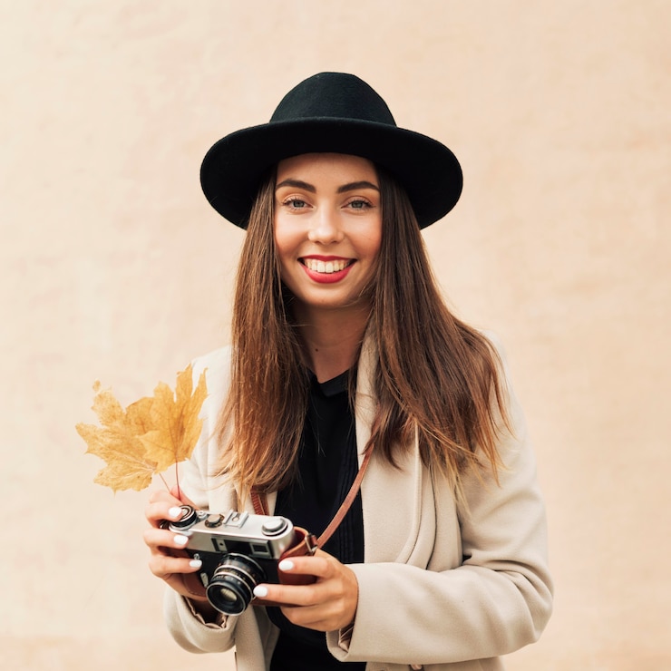 Kostenlose Foto smiley-frau, die eine kamera und ein blatt hält