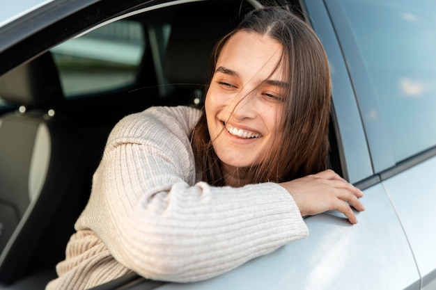 Smiley-Frau, die einen Roadtrip in ihrem Auto genießt