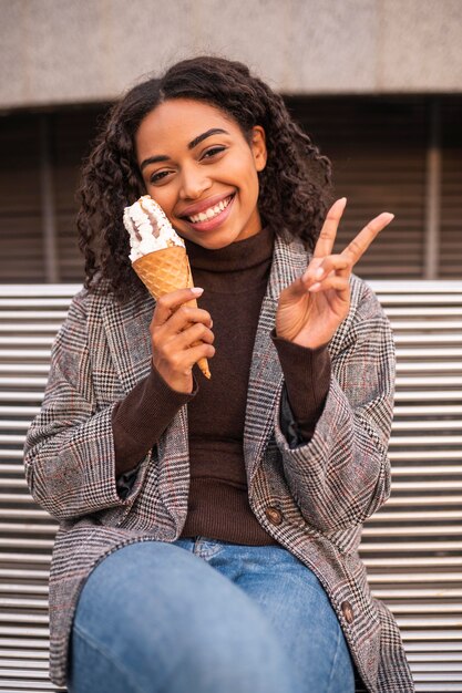 Smiley-Frau, die Eis im Freien hat