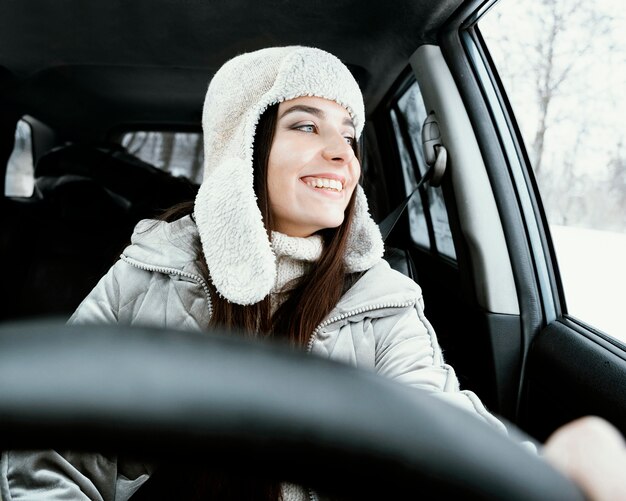 Smiley-Frau, die im Auto während einer Straßenfahrt aufwirft