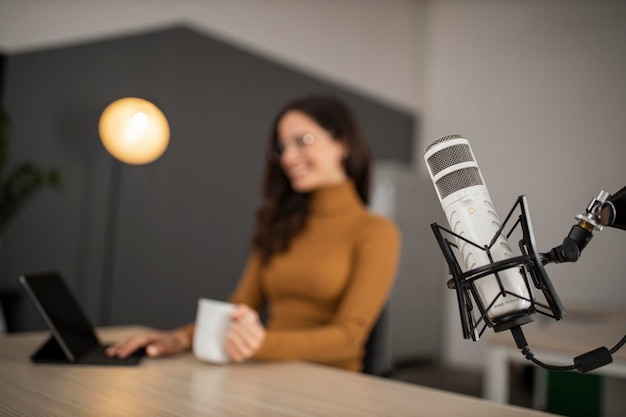 Kostenloses Foto smiley-frau, die im radio mit mikrofon sendet